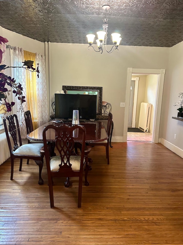 dining area with an inviting chandelier and hardwood / wood-style flooring