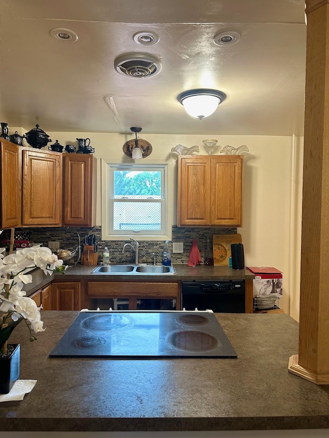 kitchen featuring decorative backsplash, black appliances, and sink