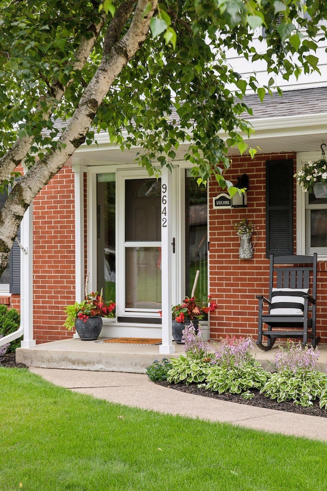 9642 Upton Rd, Minneapolis, MN 55431 - property entrance featuring covered porch, brick siding, and a shingled roof