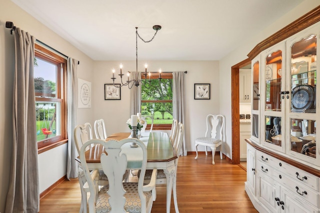 9642 Upton Rd, Minneapolis, MN 55431 - dining area with healthy amount of natural light, a chandelier, light wood-type flooring, and baseboards