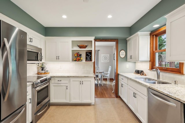 9642 Upton Rd, Minneapolis, MN 55431 - kitchen with stainless steel appliances, a sink, white cabinetry, light tile patterned flooring, and backsplash