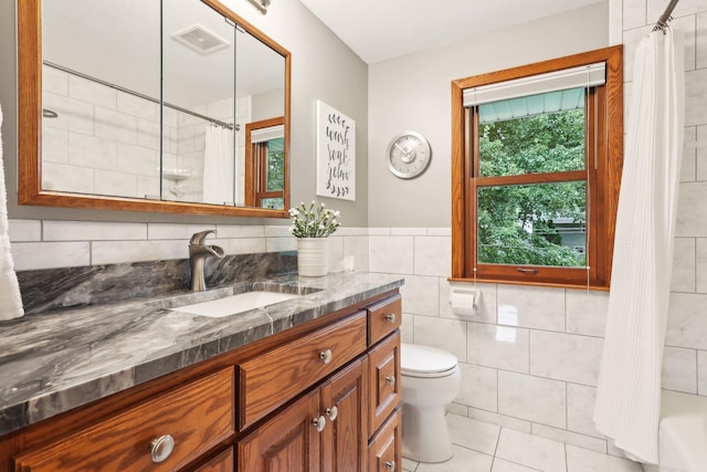 9642 Upton Rd, Minneapolis, MN 55431 - bathroom featuring vanity, toilet, tile walls, tile patterned flooring, and shower / bath combination with curtain