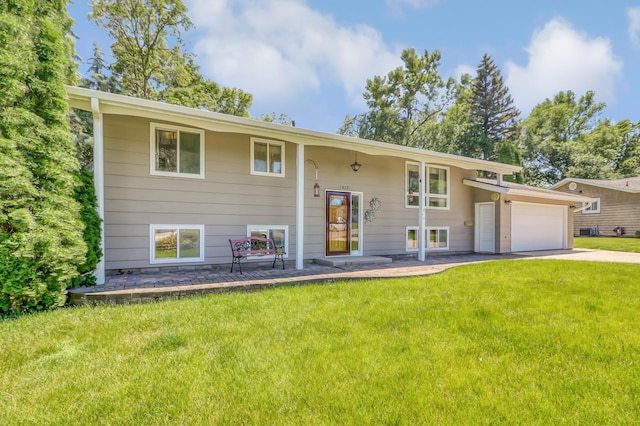 split foyer home featuring a garage and a front yard