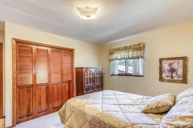 carpeted bedroom featuring a textured ceiling and a closet