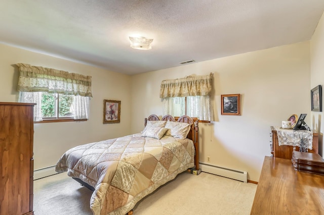 bedroom featuring carpet flooring, a textured ceiling, and a baseboard heating unit