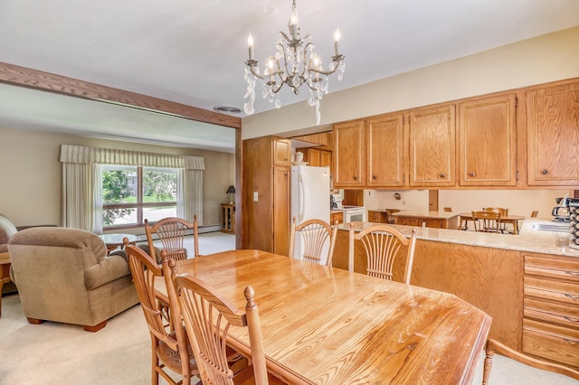 dining space featuring a notable chandelier, sink, and light carpet