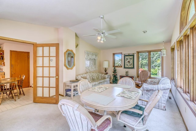 carpeted dining room with ceiling fan, lofted ceiling, and french doors