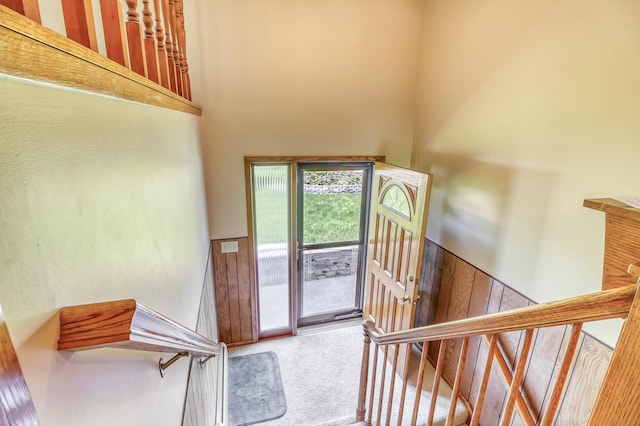 stairs featuring carpet and a high ceiling