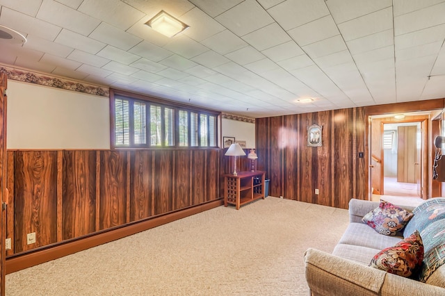 sitting room with carpet flooring, baseboard heating, and wooden walls