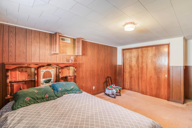 bedroom featuring wood walls, a closet, and carpet floors