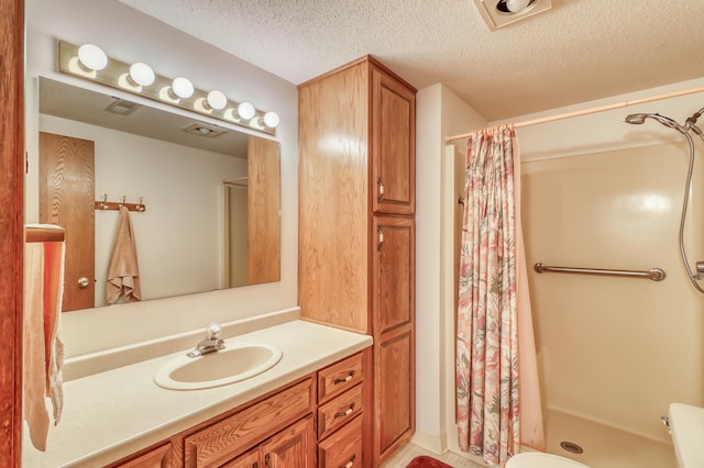 bathroom featuring vanity, a textured ceiling, and walk in shower