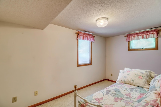 bedroom with light colored carpet and a textured ceiling