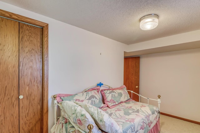 bedroom featuring carpet flooring, a textured ceiling, and a closet