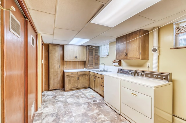 laundry room with washer and dryer, sink, and cabinets