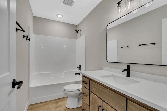 full bathroom with shower / washtub combination, wood-type flooring, vanity, and toilet