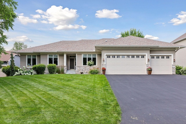 view of front of home with a front yard and a garage