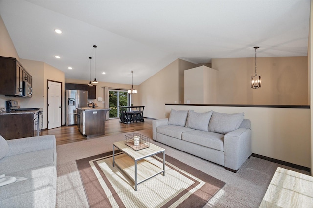 living room featuring a notable chandelier and vaulted ceiling