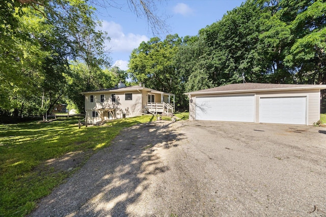 view of front of home featuring an outbuilding, a garage, and a front lawn