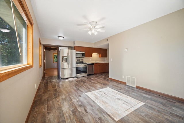 kitchen featuring dark hardwood / wood-style flooring, sink, stainless steel appliances, and ceiling fan