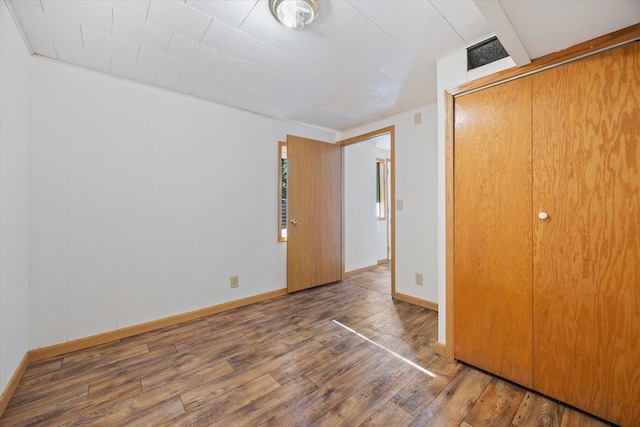 unfurnished bedroom with hardwood / wood-style flooring and a closet