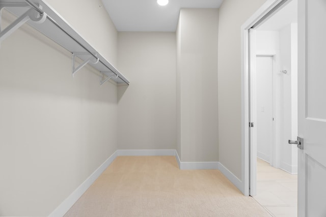 walk in closet featuring light carpet