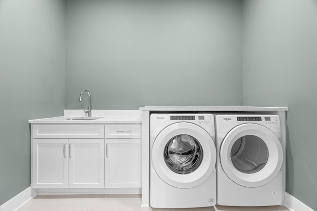 washroom featuring cabinets, sink, and washing machine and clothes dryer