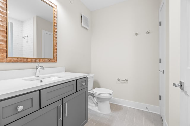 bathroom with a shower, vanity, and toilet