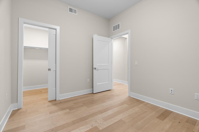 unfurnished bedroom with light hardwood / wood-style flooring and a closet