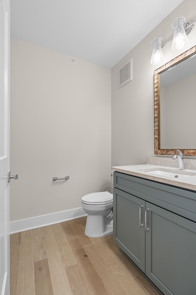 bathroom featuring hardwood / wood-style floors, vanity, and toilet