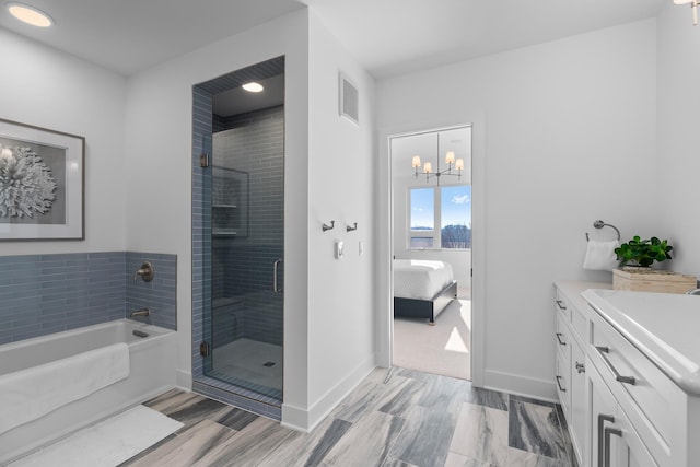 bathroom featuring a chandelier, independent shower and bath, vanity, and tile floors