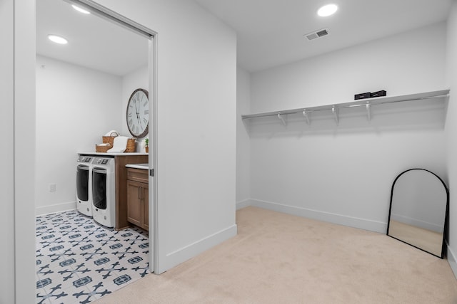 spacious closet with washer and dryer and light carpet