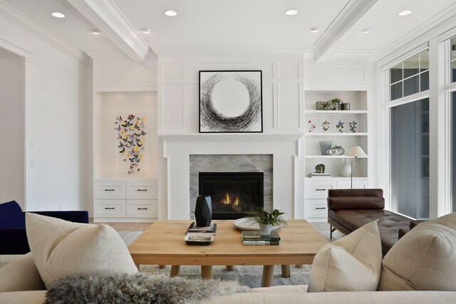 living room featuring crown molding, built in features, and beamed ceiling