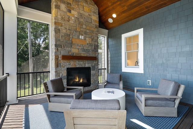 sunroom / solarium with an outdoor stone fireplace, lofted ceiling, and wooden ceiling