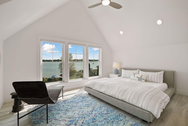 bedroom with a water view, ceiling fan, vaulted ceiling, and light hardwood / wood-style flooring