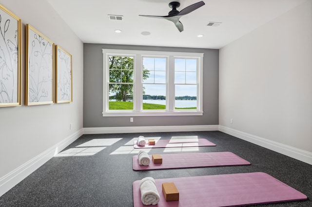 exercise area with ceiling fan and carpet flooring