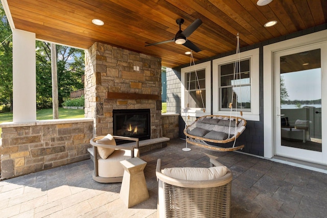 view of patio featuring an outdoor stone fireplace and ceiling fan