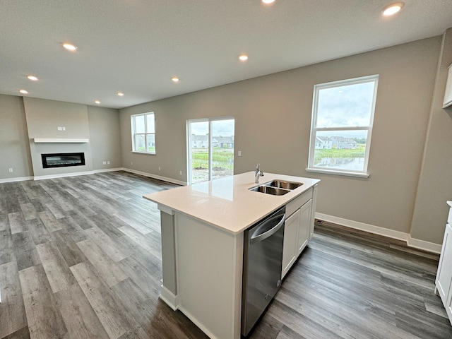 kitchen with a kitchen island with sink, light hardwood / wood-style flooring, sink, stainless steel dishwasher, and white cabinets