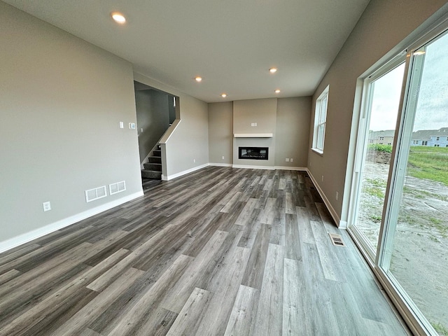 unfurnished living room with hardwood / wood-style floors and a healthy amount of sunlight