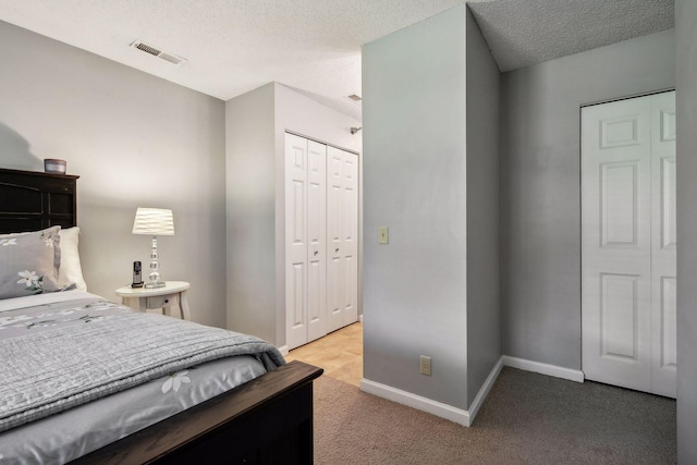 bedroom with light colored carpet, a closet, and a textured ceiling