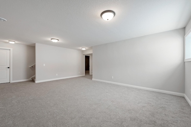 spare room with a textured ceiling and carpet flooring