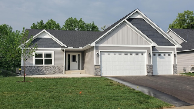 craftsman-style house featuring an attached garage, driveway, and a front yard