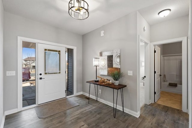 foyer featuring dark wood-style floors and baseboards