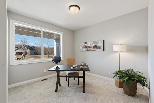 office area with visible vents, baseboards, and carpet flooring