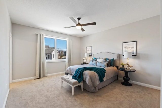 bedroom with a ceiling fan, light carpet, and baseboards