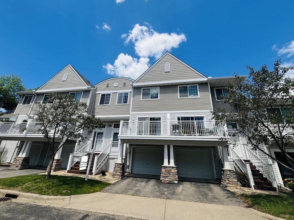 view of front of house featuring driveway, an attached garage, and stairs