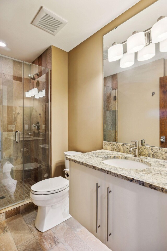 bathroom with a shower with shower door, tile patterned floors, toilet, and vanity