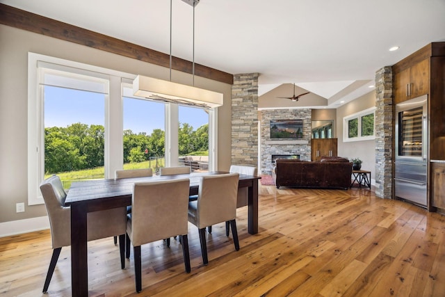 dining space featuring a fireplace, light wood-type flooring, and ceiling fan