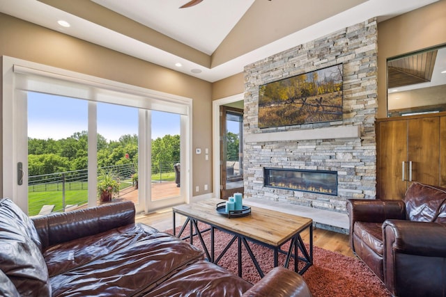 living room featuring light hardwood / wood-style floors, a fireplace, a wealth of natural light, and vaulted ceiling