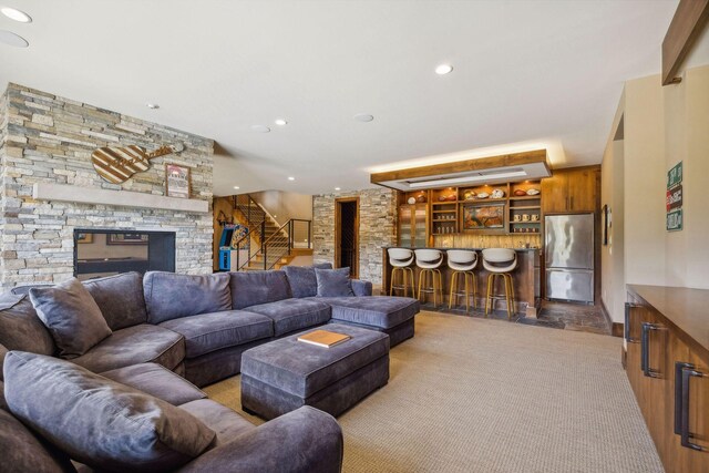 carpeted living room with indoor bar and a fireplace