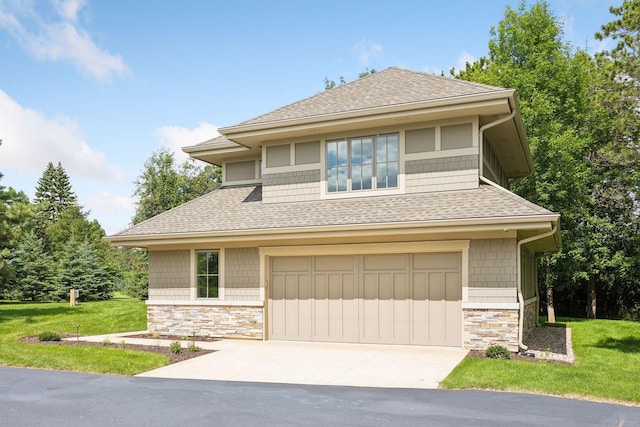 prairie-style home with a garage and a front lawn